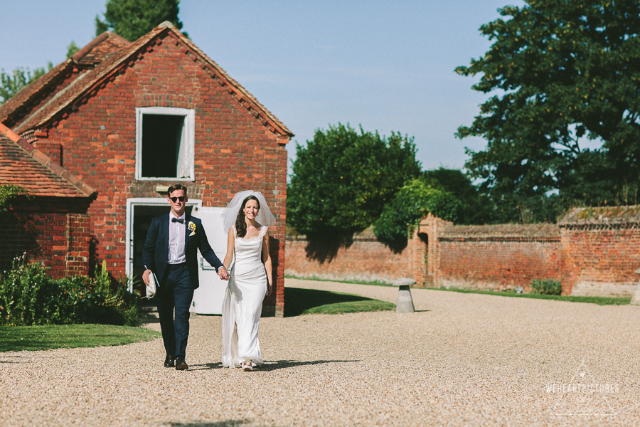 Stylish Bride and Groom Walking holding Hands, Alternative Wedding Photography