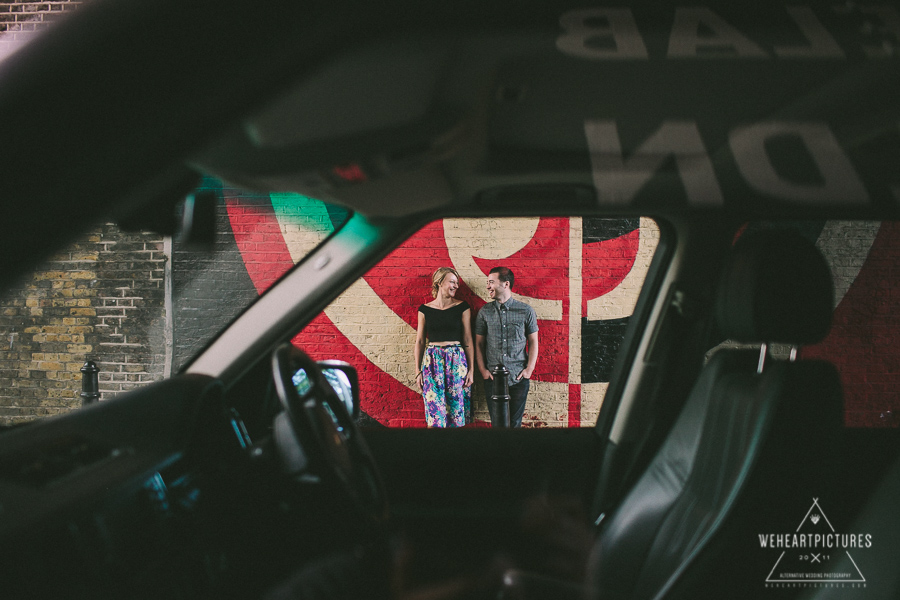 Street Art, London, Couple in Love on a photoshoot, Creative and quirky Wedding Photography, Couple Frames through a car window 