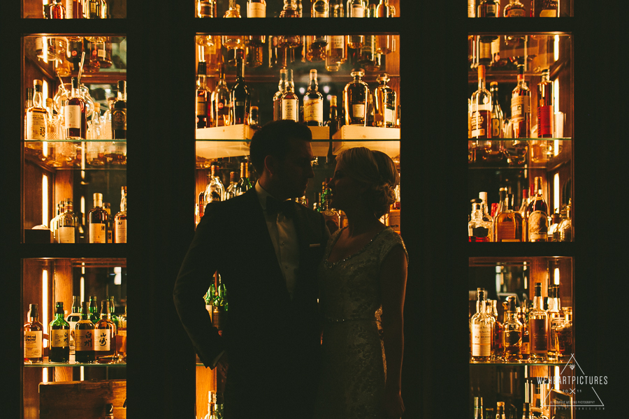 Bridal Portraits in front a bottle cabinet- London-Hawksmoor_Guildhall Wedding Photographer, Winter Wedding, Creative, Alternative Wedding Photography, Rosewood Hotel Bride and Groom Portraits.