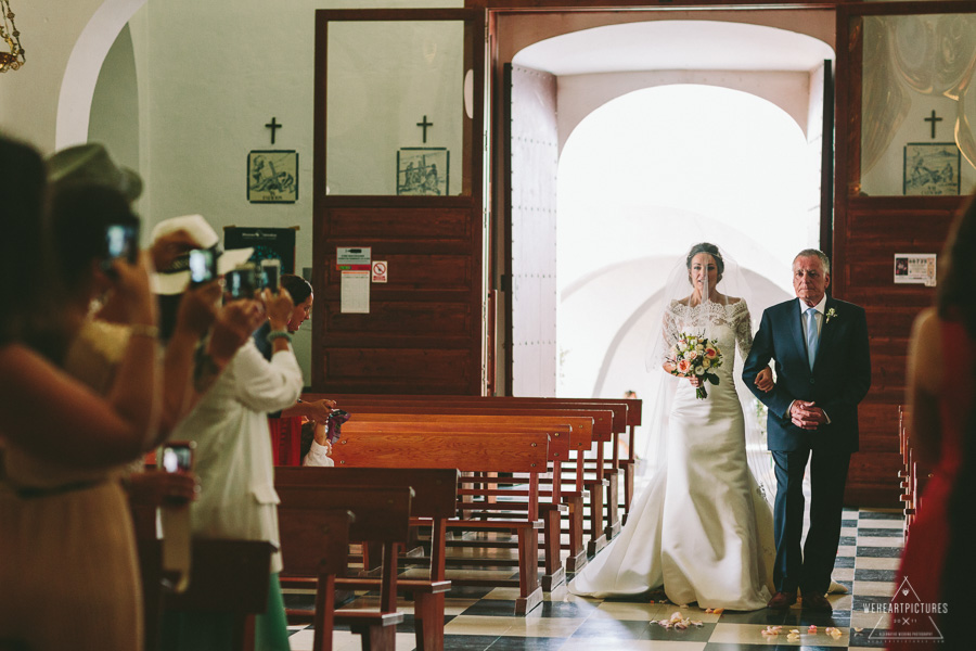 Briden entering the church in Santa Eulalia Ibiza_Here comes the bride sign_Destination Wedding Photographer_London_Europe