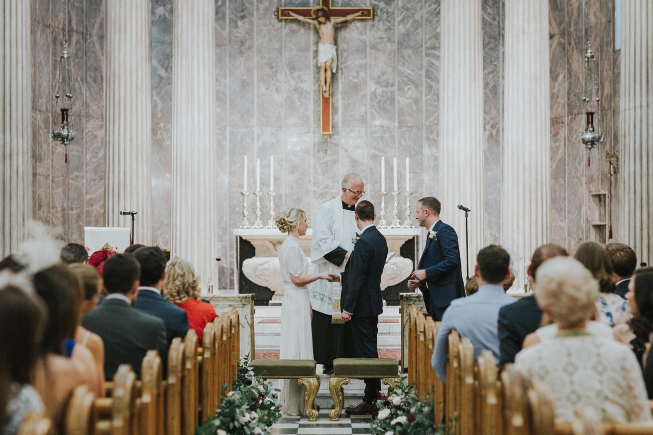 Bride and groom during their wedding ceremony at St Mary Moorfields Church London.
