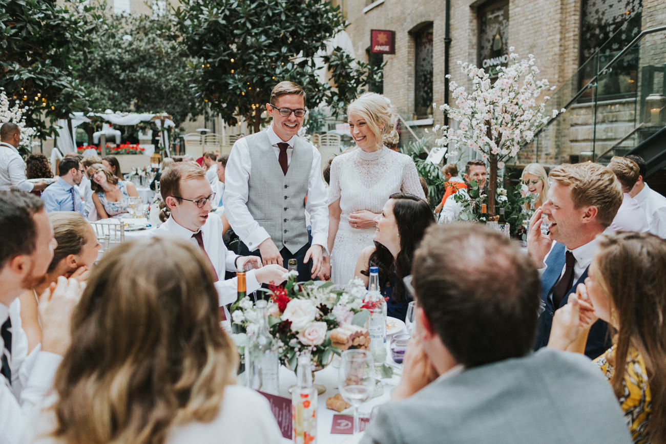 Bride and groom walking around the tables talking to guests. Devonshire Terrace Wedding London Alternative Wedding Photographer.