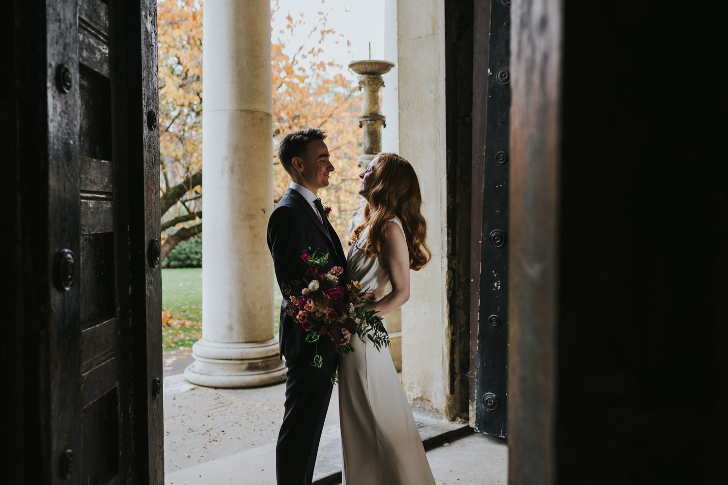 newly wed couple standing in the light of the doorway
