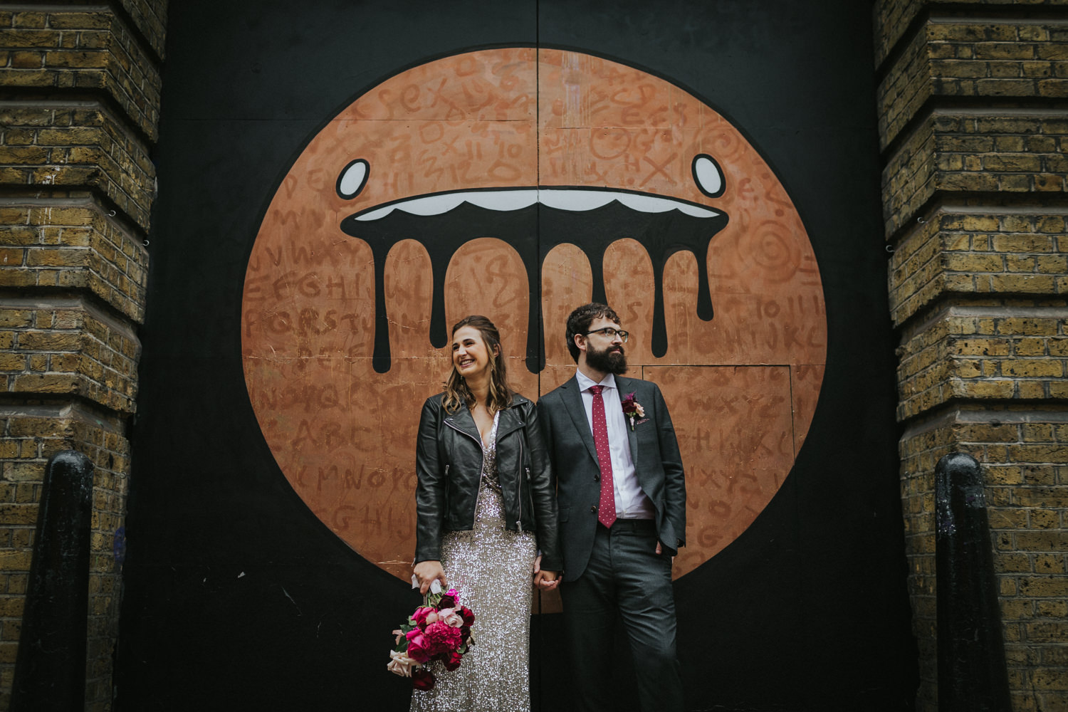 Bride and Groom in front of street art in East London.