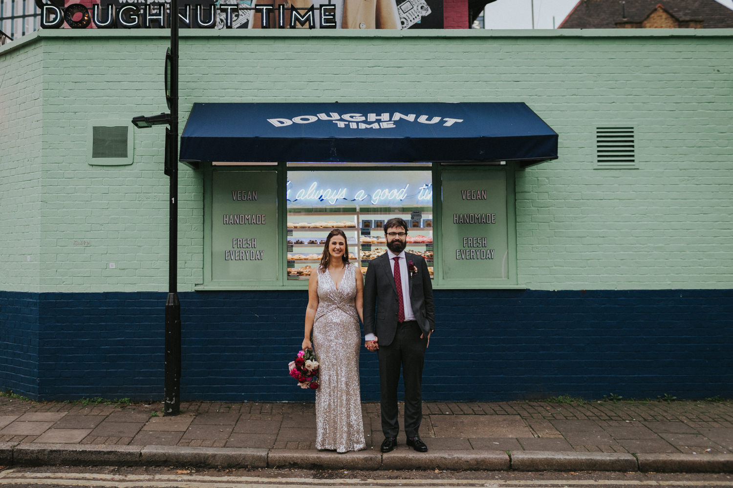 Bride and Groom in front of a doughnut shop t in East London. Wes Anderson Style.
