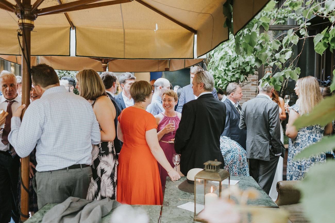 Guests mingling during a wedding at Petersham Nurseries in Covent Garden.