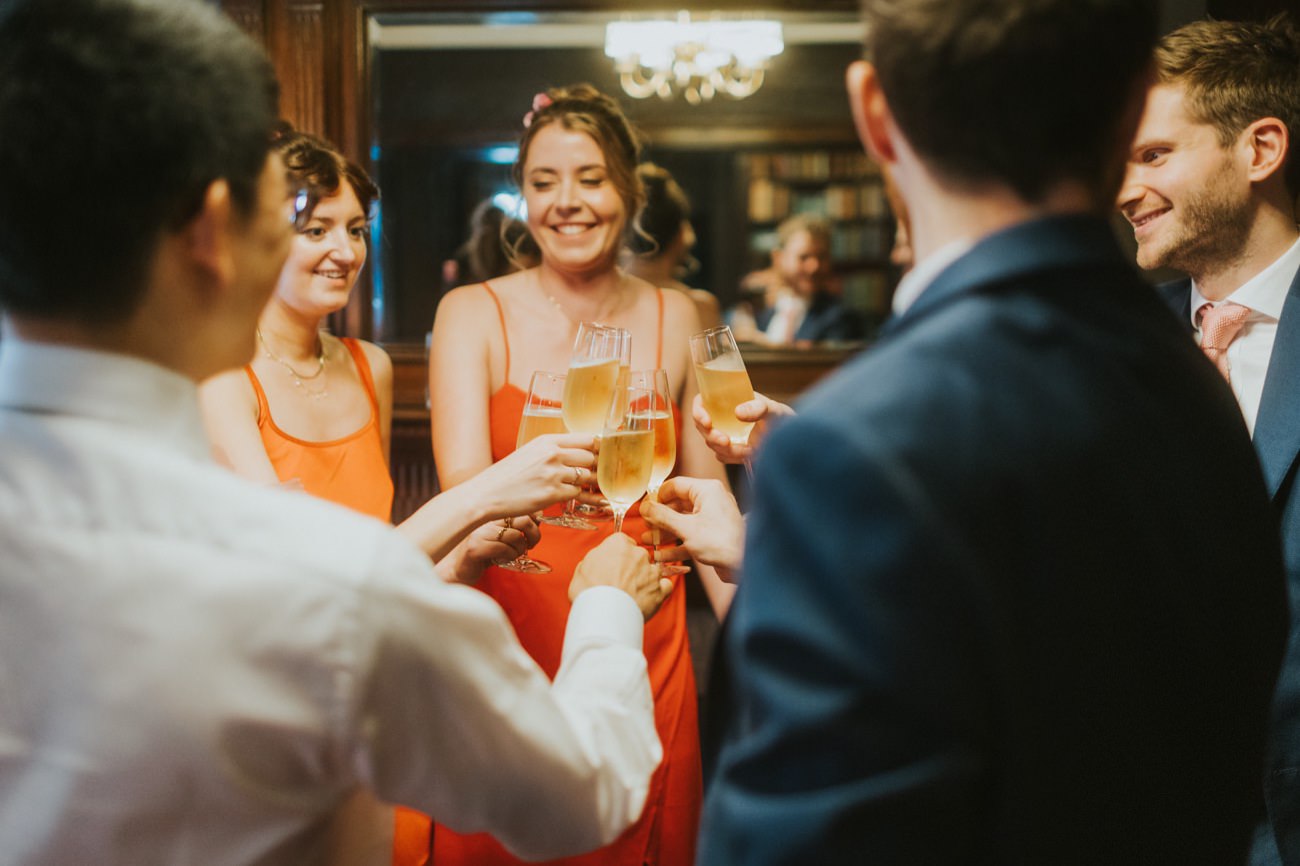 Guests drinking champagne wearing beautiful orange dresses